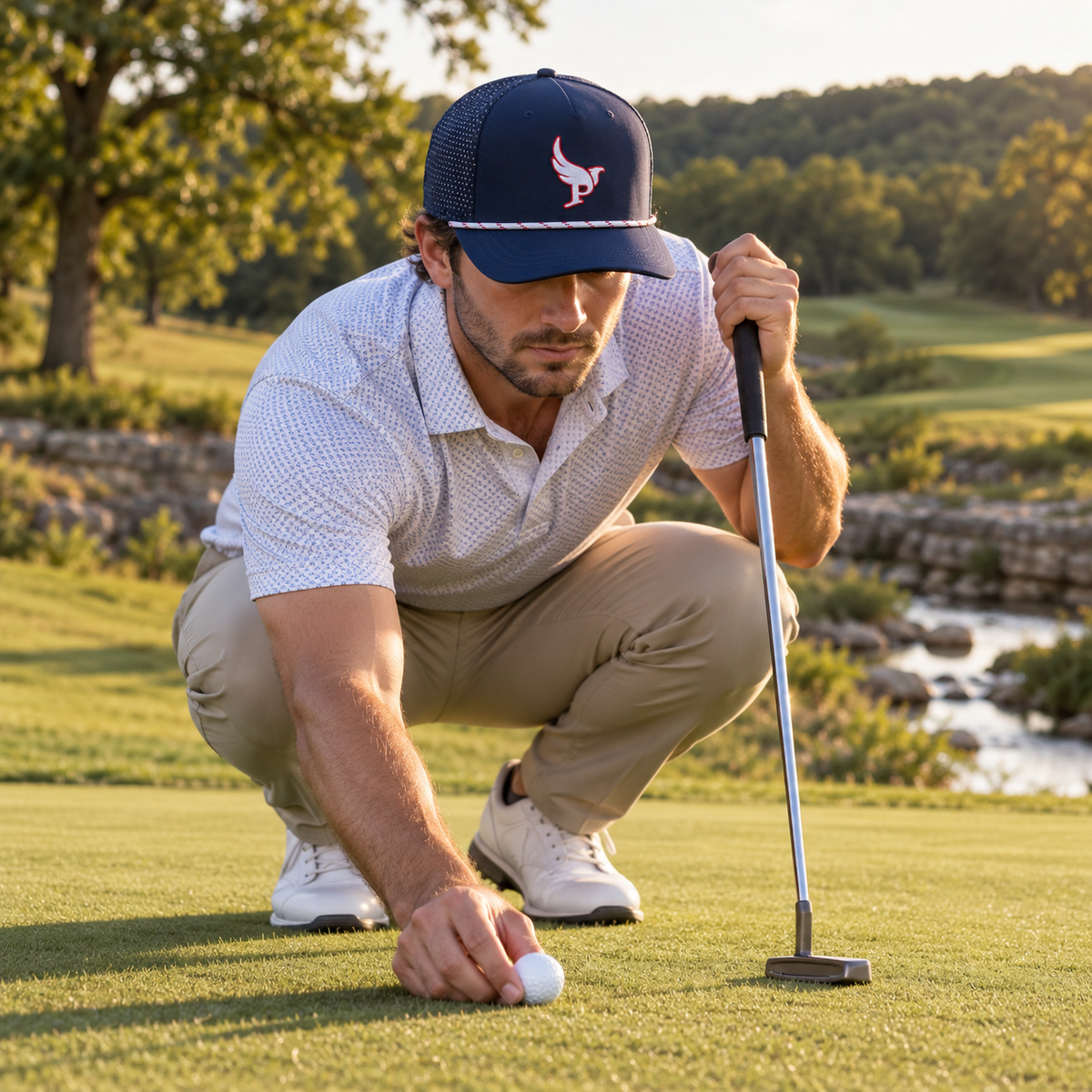 Golfer marking his ball in The Low Harpy Snap in Navy with White/Red/Royal rope